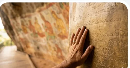 touching the golden-colored ancient Mirror Wall at Sigiriya